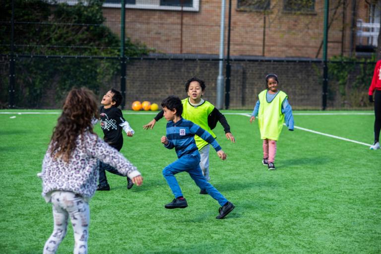 Children playing football in playground.