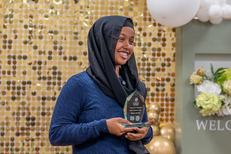 winner of young leaders award holds her trophy