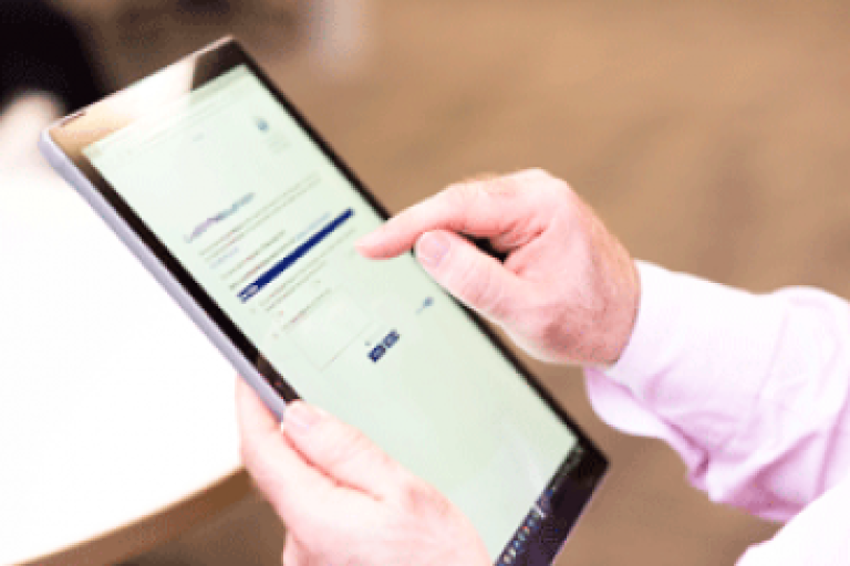 A hand scrolling down a webpage on an iPad