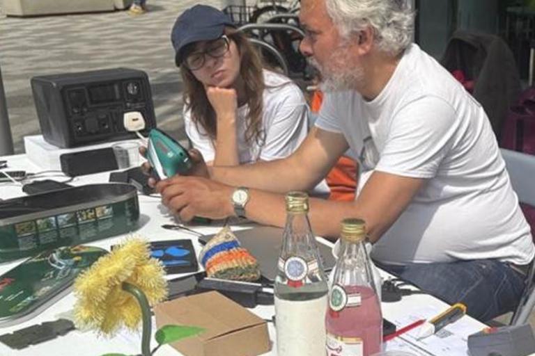 Man fixing item with young person watching