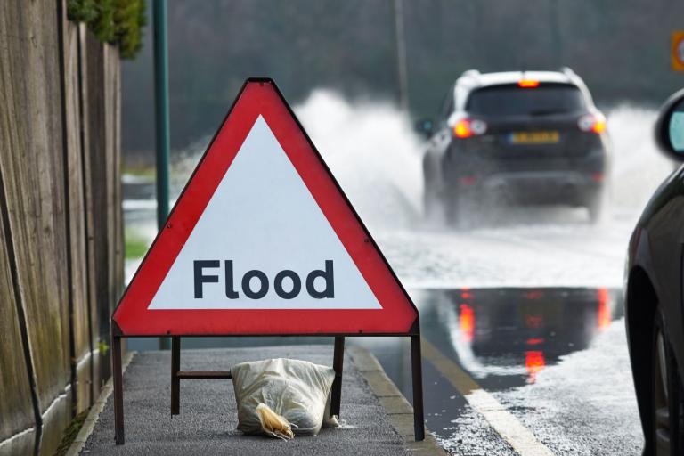 Photo of flood street sign on a flooded street.