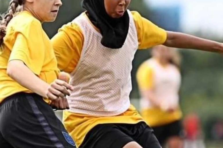 Two girls playing football
