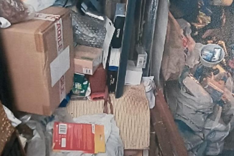 Image of boxes, bags and rubbish items piled high