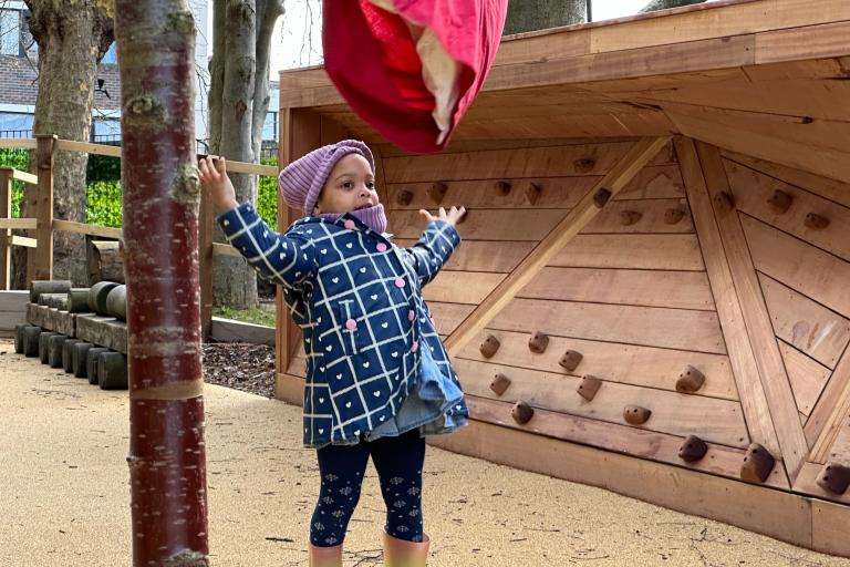 A child plays in the garden of Grenfell Nursery
