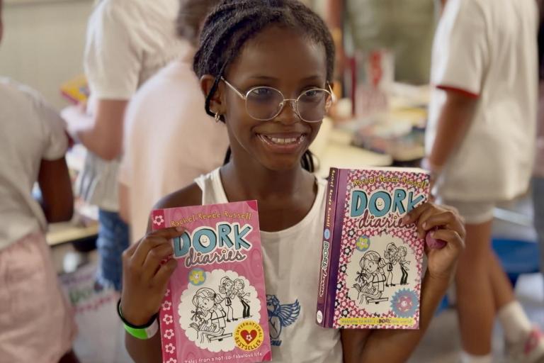 Girl holds up two books