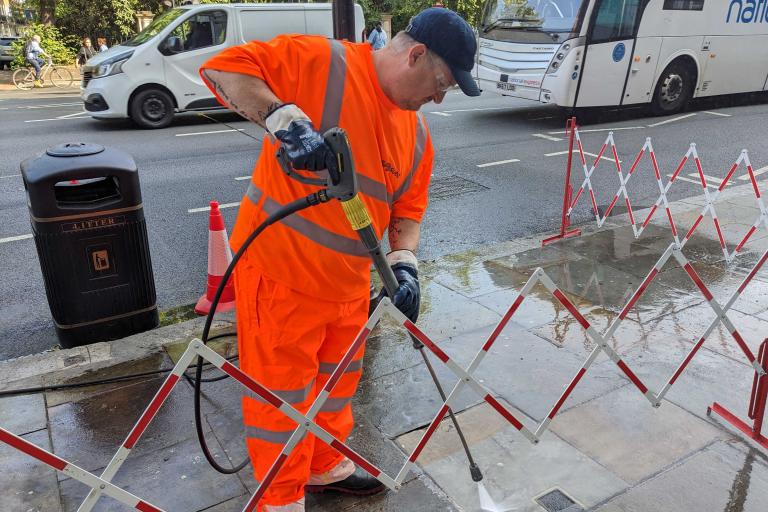 A worker jet washes pavements in South Kensington