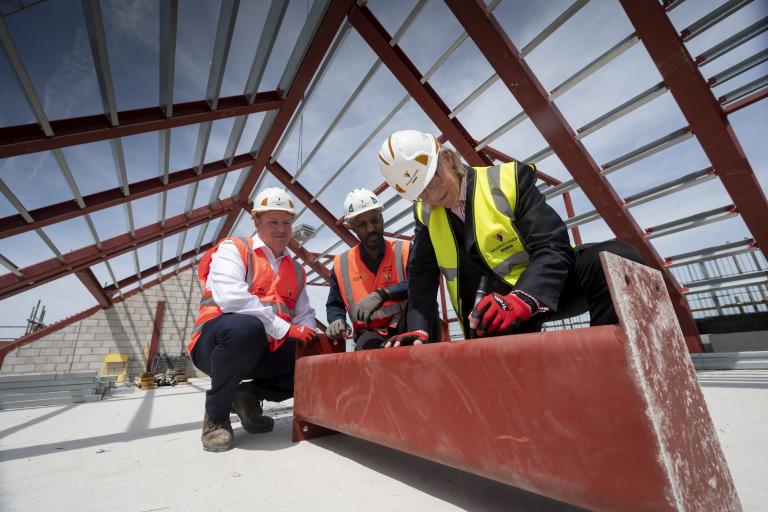 Cllr Kim Taylor-Smith, Lead Member for Grenfell Housing, Housing and Social Investment, Courtney Edwards – Construction Manager, Willmott Dixon and Neil Locke – Senior Operations Manager, Willmott Dixon sign the final steel beam to be placed at the top of the Kensal Road development