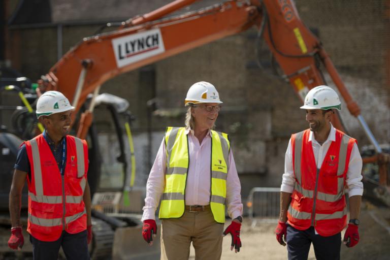 Construction workers with a digger in the background.