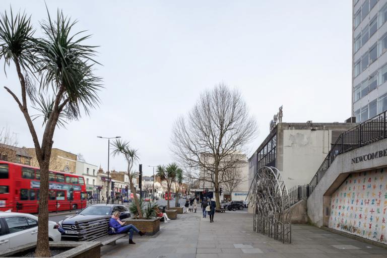 A street with wide pavement space and tree lining it