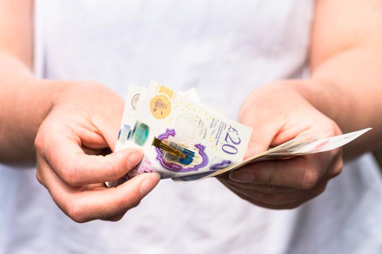 An image of a person holding money in her hand