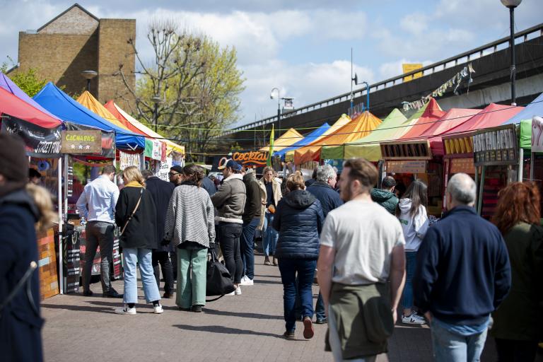 People shopping at colourful market stalls