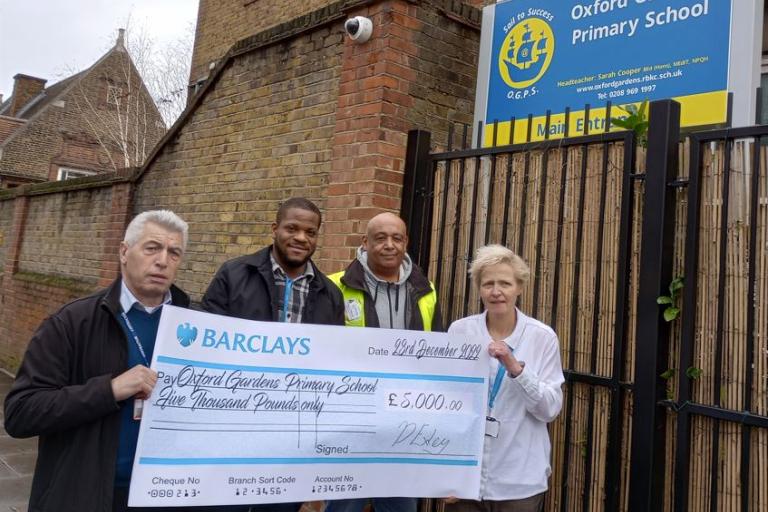 Members of the project team and Headteacher of Oxford Gardens Primary School holding large £5,000 cheque outside the school