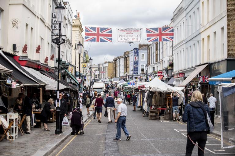 Portobello Road with street market stalls and people walking around