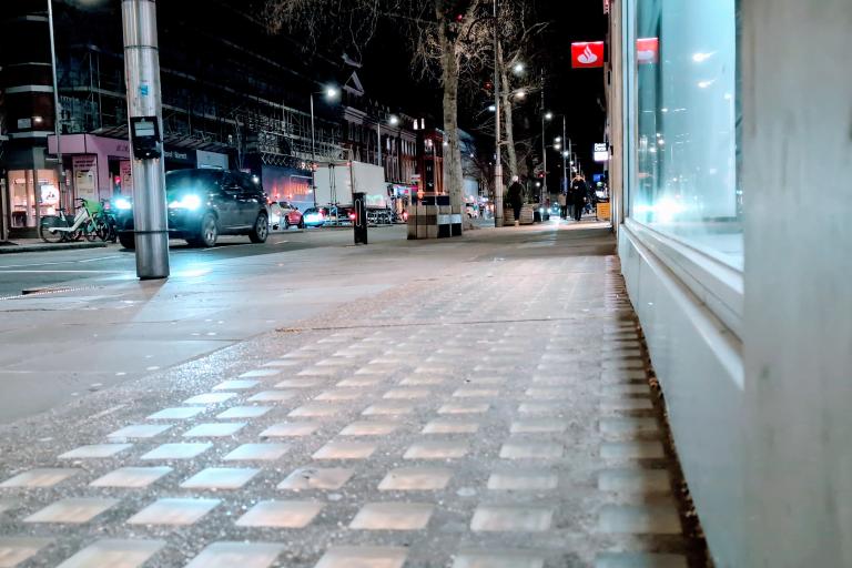 A shot of Kensington High Street at night from ground level