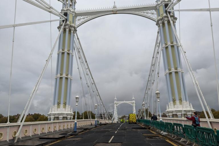Showing Albert Bridge from the road with roadworks barriers and vans