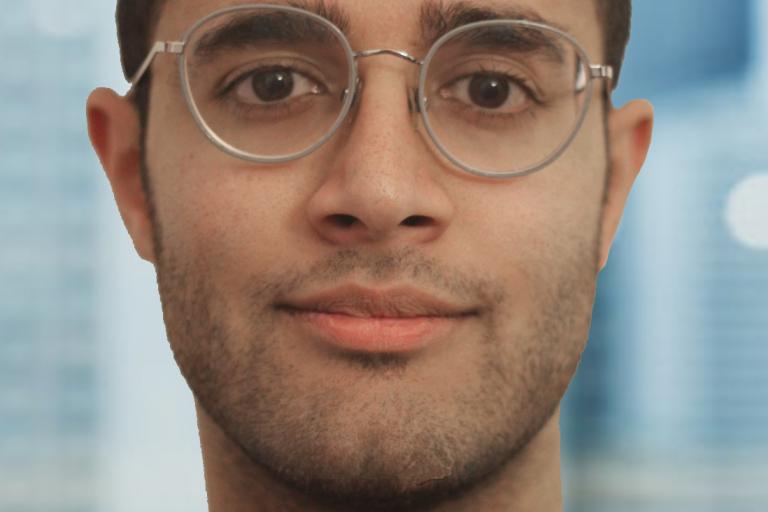 young male wearing dark framed glasses with out of focus background