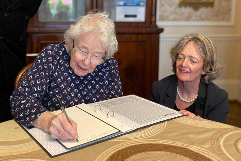 A sheltered housing resident signs a book of condolence following the passing of Queen Elizabeth II