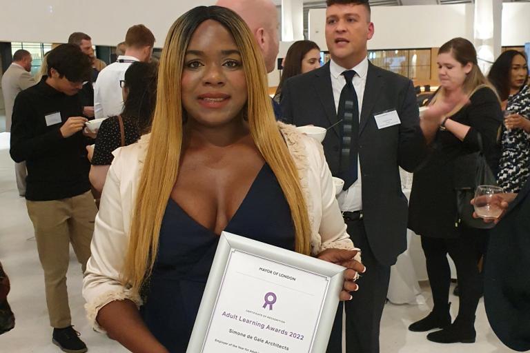 Winner for employer of the year stands facing the camera