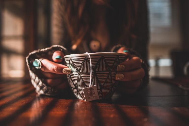 A woman holding a hot cup of tea