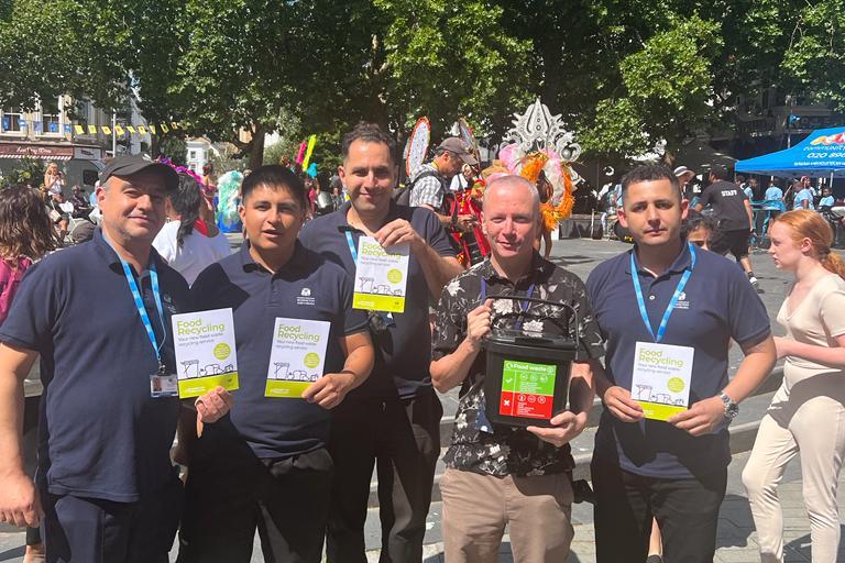 Image of RBKC staff holding waste bin caddies and leaflets