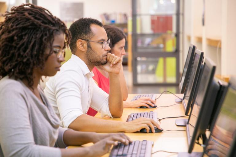 A group of people using computers at a library