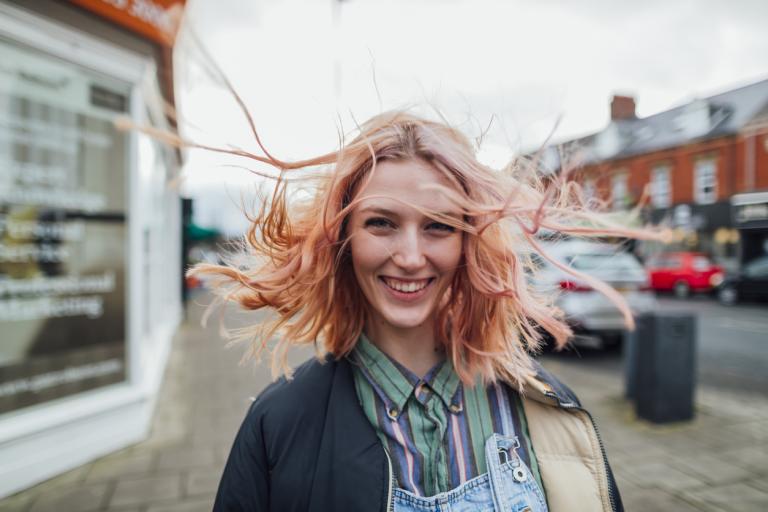 Young woman with pink hair smiling