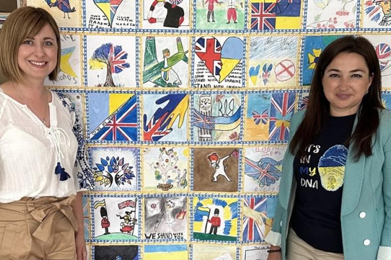 Staff at St Mary's Ukrainian School in Holland Park pose in front of artwork