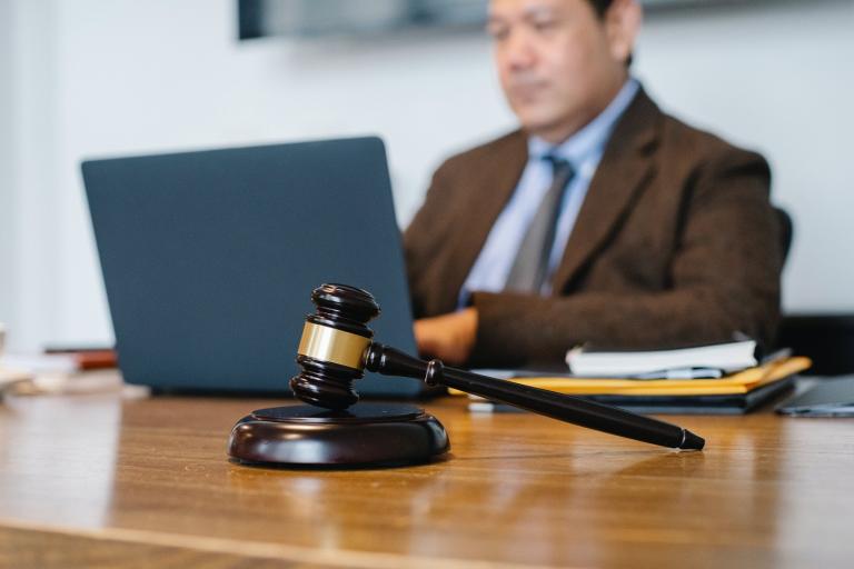 A judge sits behind his computer considering if someone is guilty