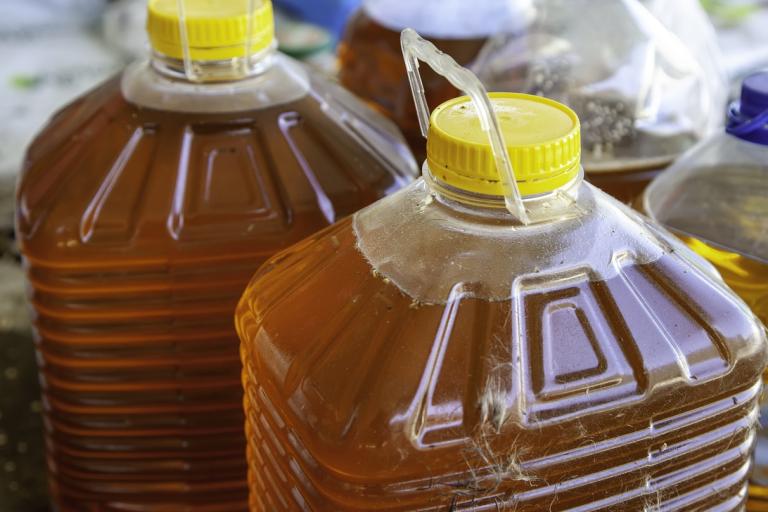 two large plastic bottle of cooking oil with yellow lid and carry handle