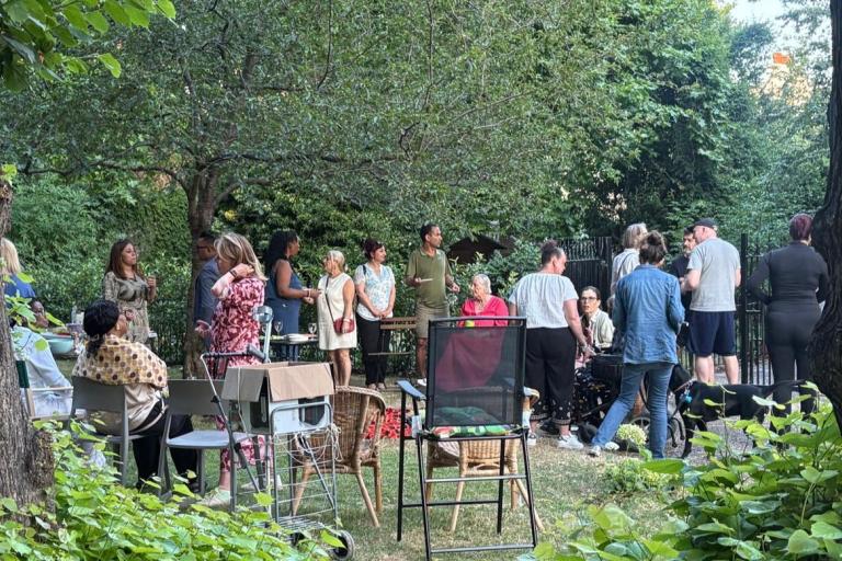 Residents gather in communal garden surrounded by greenery