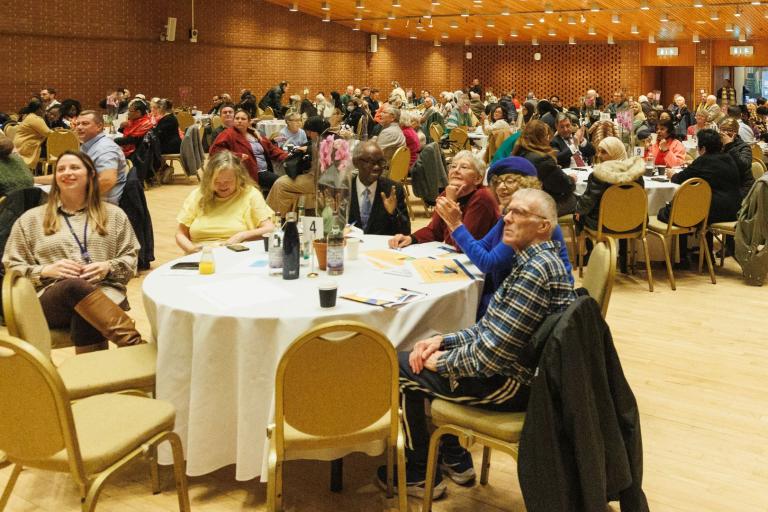 image of group of people around tables in discussion