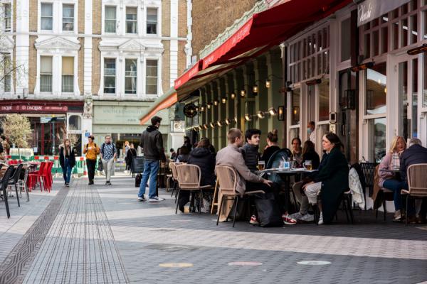 A pedestrianised street with outside dining and restaurants. 