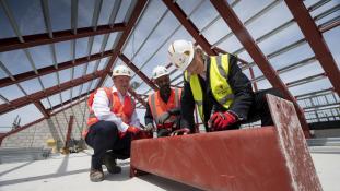 Cllr Kim Taylor-Smith, Lead Member for Grenfell Housing, Housing and Social Investment, Courtney Edwards – Construction Manager, Willmott Dixon and Neil Locke – Senior Operations Manager, Willmott Dixon sign the final steel beam to be placed at the top of the Kensal Road development
