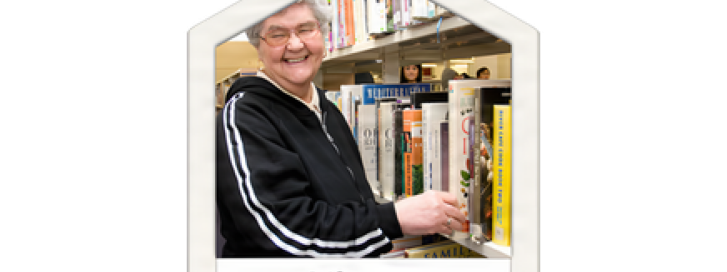 Person choosing a book from a library shelf