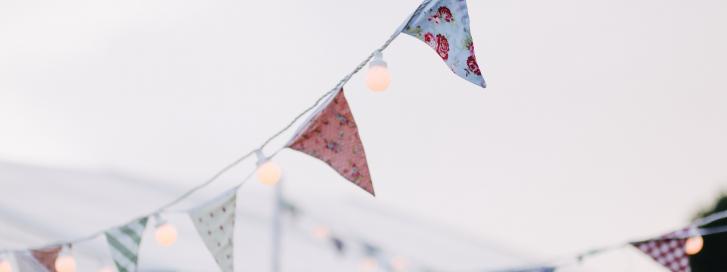 Bunting strung with fairy lights against grey sky