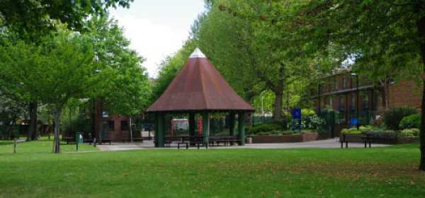 Witches Hat’ shelter with seating in the old Athlone Gardens, surrounded by green lawns and mature trees.