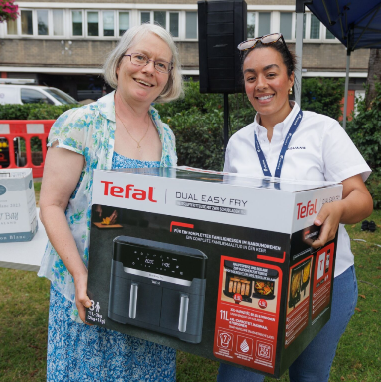 new air fryer in box being handed to raffle winner by equans officer