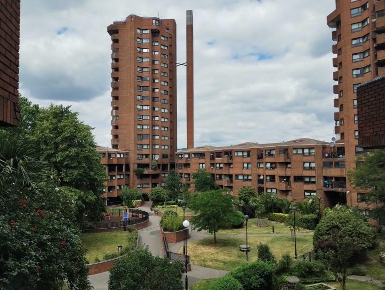 a view of the central shared garden on the worlds end estate. a green area surrounded by brick tower blocks