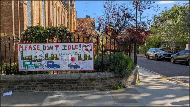 A sign saying "Please don't idle!" on a wall