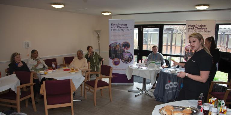 residents of sheltered housing listening to the building safety manager talking about smoke and fire alarms 