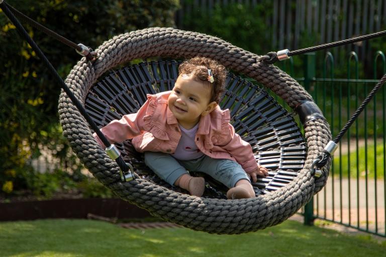 Child on swing seat in Avondale Park