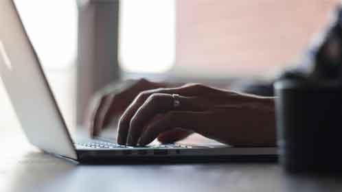 A man typing on his laptop