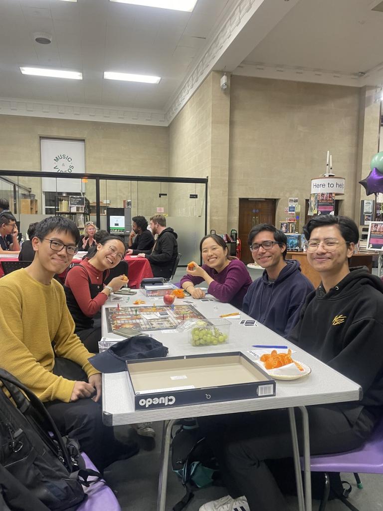 a group of people playing a board game in the library 