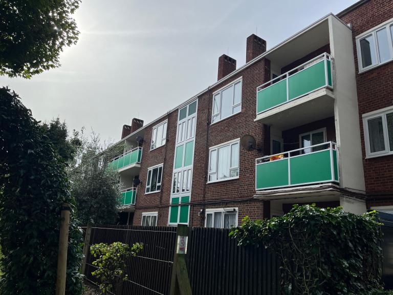 Low rise apartment block with green panelling