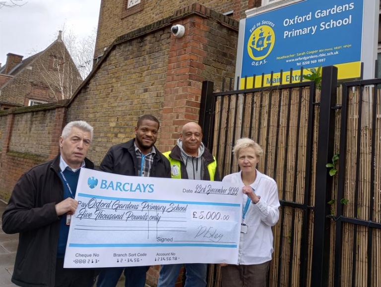 Members of the project team and Headteacher of Oxford Gardens Primary School holding large £5,000 cheque outside the school