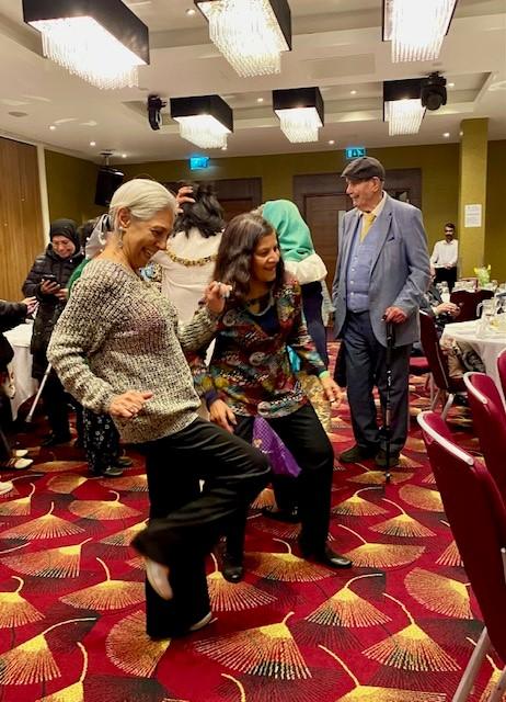 Two women dancing at a luncheon event