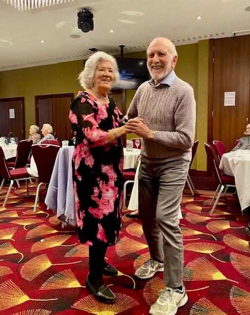 A man and a woman dance at a lunch event
