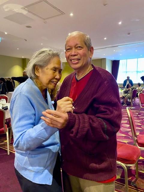 A man and a woman dance at a lunch event