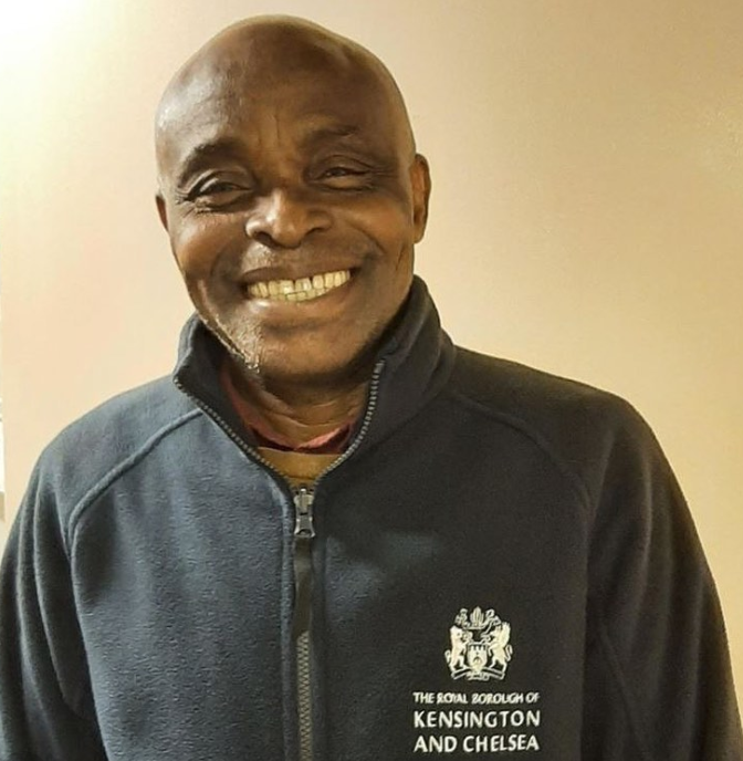 Image of a black bald man smiling at the camera wearing a navy blue fleece with the Council logo on it