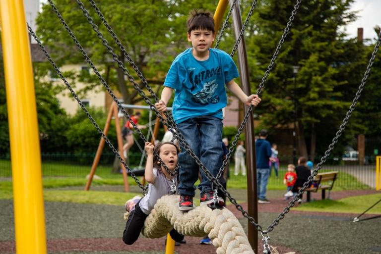 Children playing on rope snake swing in Avondale Park